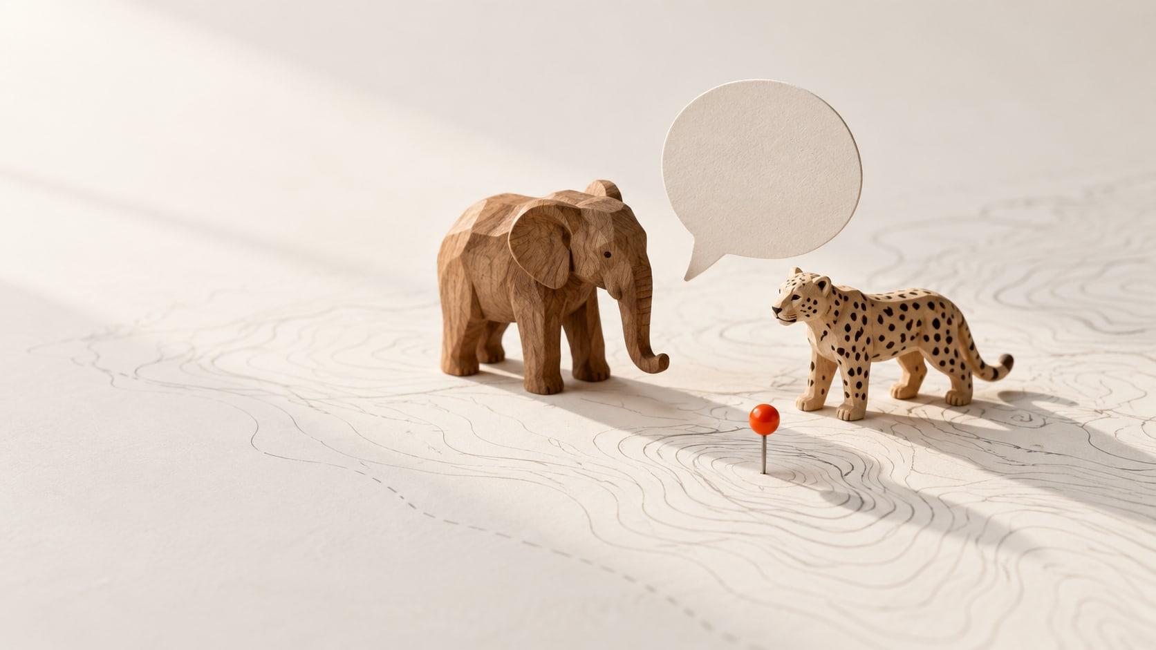 Wildlife Chatbot: carved elephant and leopard figures on a contour map beside a paper speech bubble
